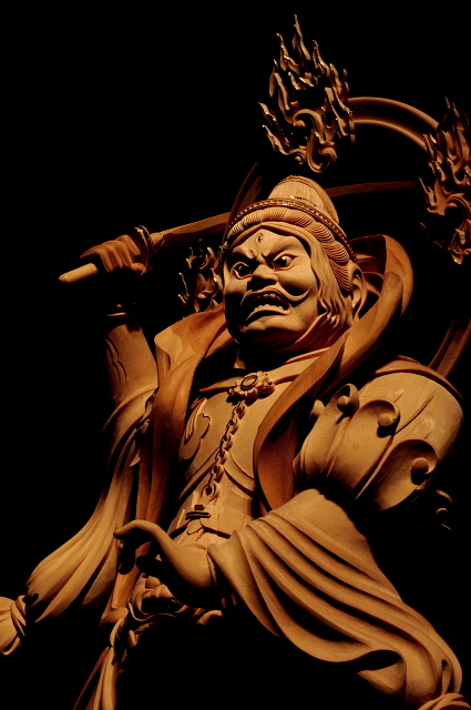 仏像彫刻原田謹刻 散脂大将像(さんじたいしょうぞう) 【散脂大将】 毘沙門天の眷属。八大夜叉大将の一尊。二十八部衆の一尊。パーンチカ。 【夜叉~やしゃ】 古代インド神話に登場する鬼神。薬叉(やくしゃ)とも称する。のちに仏教に取り入れられ護法善神となった。 【毘沙門天と八大夜叉大将】 毘沙門天は、元々暗黒界に住する夜叉鬼神の長とされ、毘沙門天(クベーラ)が仏教に帰依したことにより、悪鬼羅刹夜叉などの類も仏教に帰依する形となった。元々悪鬼であった夜叉等は、善神として毘沙門天やその他の神々と共に祀られるようになった。 その配下に属する夜叉は5000とも云われ、その頂点に立つのが八大夜叉大将である。常に毘沙門天の指示に随い、祈願する者を守護すると云われるが故に、守護八大夜叉神とも称される。 【パーンチカとハーリーティー】 パーンチカ~散脂夜叉の妻は鬼子母神(ハーリティー)。ハーリーティー・パーンチカ夫婦は数百人の子ども(一説によると500人)を抱えるという。
