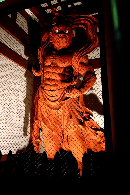 仏像彫刻原田謹刻 仁王像(におうぞう)総高5㍍ 【仁王】 仏教の守護神。サンスクリットではヴァジュラダラと言い、「金剛杵(こんごうしょ、仏敵を退散させる武器)を持つもの」を意味します。二王ともかき,金剛神・金剛力士とも呼ばれ、山門の左右に安置され、仏法僧を守護するのがお役目です。元来はインド神話の神で,武装姿もありますが,日本では裸姿の力士像がほとんどのようです。向かって右は金剛杵(しょ)をもち口をあけた阿形(あぎょう)で,左は口をとじた吽形(うんぎょう)となります。そのルーツをたどるとギリシア神話の英雄ヘラクレスに行きあたります。