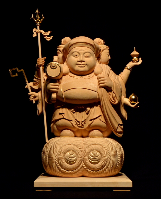 仏像彫刻原田謹刻 三面大黒天像(さんめんだいこくてんぞう) 【三面大黒天】 正面に大黒天,右面に毘沙門天,左面に弁才天の三つの顔をもつ大黒天。 福徳、財富、知恵、延寿を授け、仏法を守護する。 ◆お施主様より、ご面相、持物、体躯などの像容を、写真や言葉で詳細に示して頂き、そのご指示に副って謹刻させていただきました。お施主様から最初にご対面頂いた際、「大黒様のお顔、ご寄進された方の面影があります!」とのお言葉を頂き、驚き、そして感動致しました。心より感謝申し上げます。 合掌