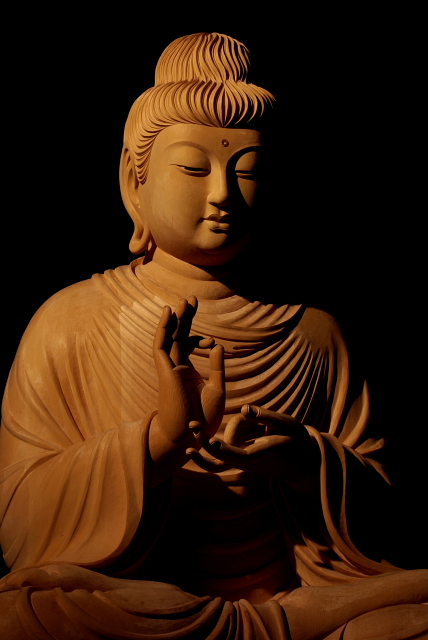 仏像彫刻原田謹刻　釈迦説法像 お釈迦さまが説法をされているお姿です。 頭髪と衣はガンダーラ仏の様式を取り入れてあります。 以下、初転法輪（しょてんほうりん）に関しての記述です。 初転法輪（しょてんぽうりん）とは、お釈迦様が初めて仏教の教義（法輪）を人びとに説いた出来事を指します。 具体的には、お釈迦様が菩提樹下で悟りを開いた後、鹿野苑で元の5人の修行仲間に初めて仏教の教義を説いた出来事を指します。お釈迦様は当初、仏法の説明は甚だ難しく、衆生に教えを説いても理解されず徒労に終わるだろうと、教えを説くことをためらったとされます。
