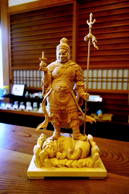 仏像彫刻原田謹刻 多聞天像(たもんてんぞう)総高35㎝ 「孫の誕生を記念して多聞天を」 とのご用命をいただき8か月。先日、完成したお姿を無事納めさせていただきました。そして本日、嬉しいお便りを頂戴致しました。 『大変見事な出来栄えに家内一同喜んでおります。満1才の誕生祝いにも間に合い、多聞天を囲んで盛り上がること間違いなしです!』 ご家族皆さんでお姿をお迎えいただき、お喜び頂いているご様子を想像し、あたたかい気持ちになりました。仏工一同の励みとさせていただきます。 お孫さんの事を多聞天様がずっと見守って下さり、多くを聞き、健康でたくましく、健やかにご成長されます事を心からお祈り申し上げます。ありがとうございました。 合掌